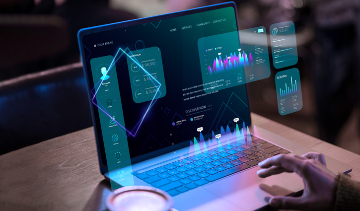A person uses a laptop displaying futuristic holographic interfaces, showcasing 2024 growth with dynamic charts and geometric shapes. In the dimly lit room, the focus on technology is palpable. A cup of coffee rests beside the laptop, fueling innovation and progress.