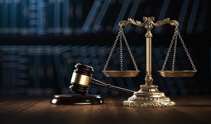 A brass balance scale and a wooden gavel sit on a desk, with blurred bookshelves in the background. The scene symbolizes expanding jurisdictions and law, emphasizing justice amid evolving pay transparency laws.