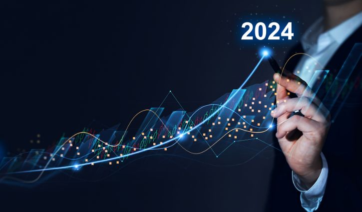 Tech Staffing Industry Faces Mixed Sentiments and Economic Uncertainty; Modest Growth Expected for 2024 9 A person in a suit uses a digital pen to trace an upward trend line on a virtual financial chart, highlighting progress towards 2024 amidst economic uncertainty. The image features stock market graphs and data points in a futuristic style.