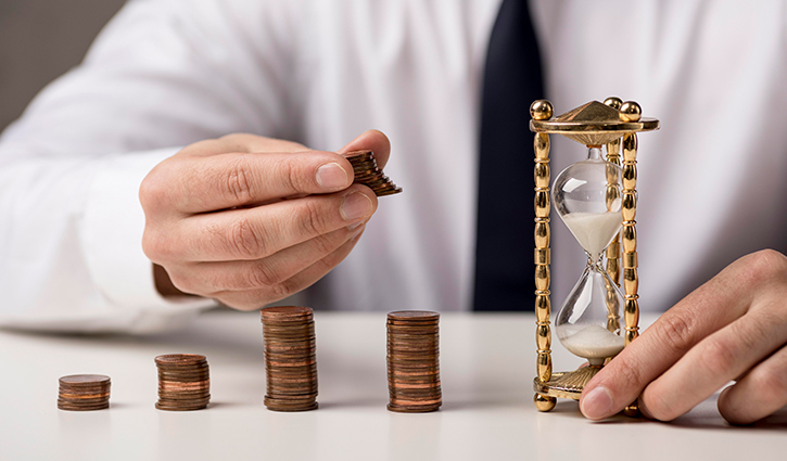 A person in a white shirt and tie stacks coins into piles of increasing height on a table. Beside them, an ornate hourglass with white sand symbolizes the passage of time, emphasizing the connection between technology, time, and money.