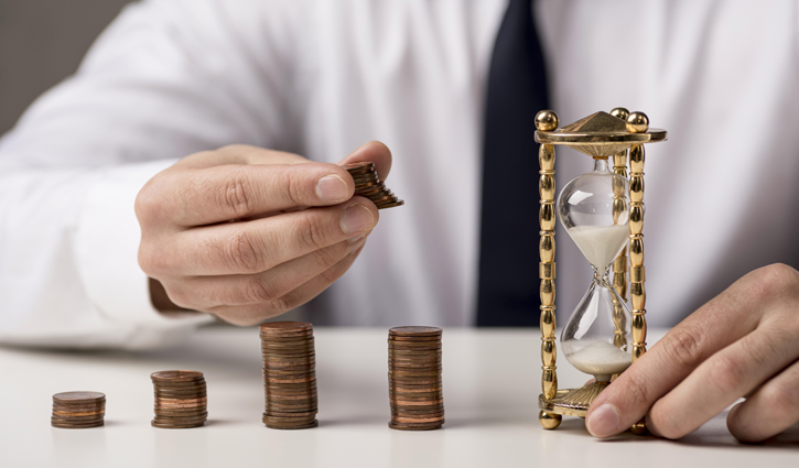 A person in a white shirt, representing white-collar employees, stacks coins in ascending order beside an ornate hourglass on a white surface. Sand flows through the hourglass, symbolizing the passage of time and financial growth or investment.