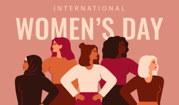 Illustration of five diverse women in staffing standing confidently with their hands on their hips against a pink background. The text reads International Womens Day in bold letters at the top, celebrating diversity and inclusion.