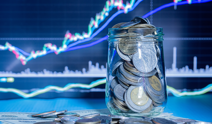 A glass jar filled with various coins rests on a surface alongside scattered dollar bills, hinting at Provident Commercial Finance’s latest activity. In the background, a financial chart with rising lines is displayed on a screen, suggesting stock market fluctuations.